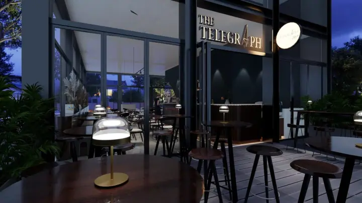 A dog resting beside its owner at the covered outdoor terrace of The Telegraph by Olivia at Guoco Midtown on Beach Road, Singapore, with the bistro's open frontage and modern industrial design visible inside.